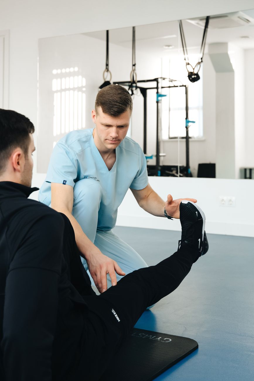 Fisioterapeuta auxiliando paciente em exercício de reabilitação